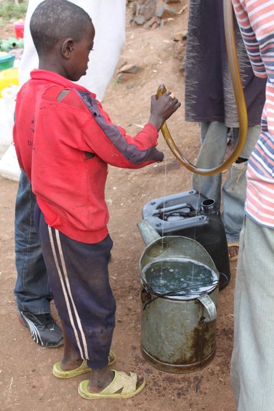 A young child helps us get petrol from the black market in Konso