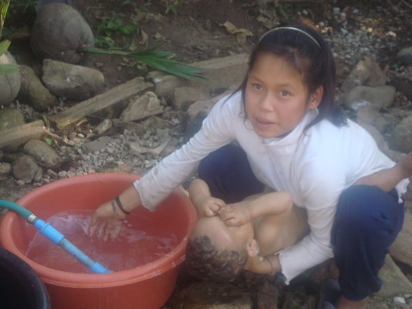 sister washing brother at orphanage