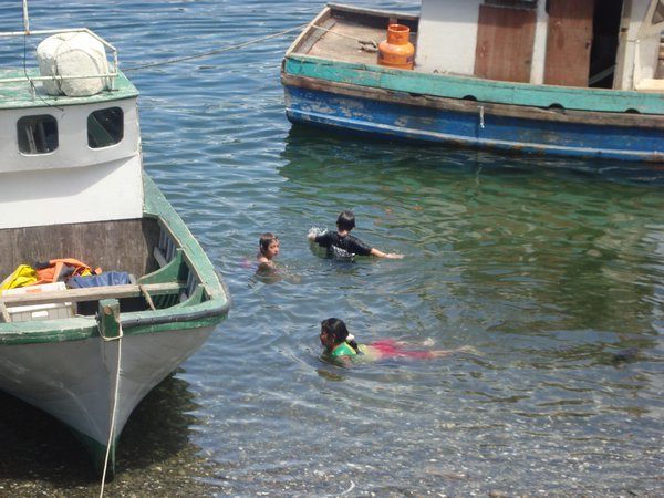 Kids swiming around port and fishing village