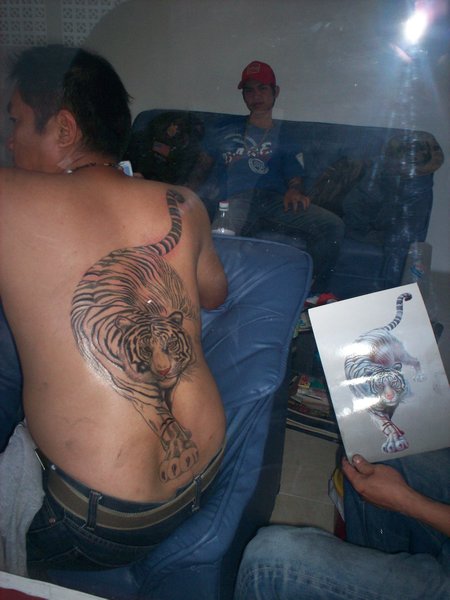 Guy getting a bamboo tattoo