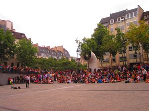 Tons of people circle up to watch mime at Pompidou courtyard