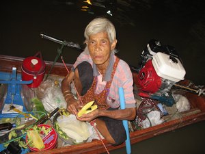 78 years old Thai lady selling mango in the night market