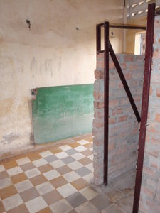 A blackboard from the classroom still there beside the brick cells