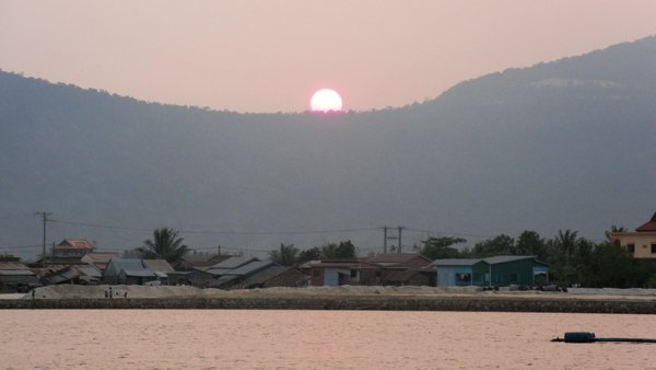 The sun sets over the river in Kampot