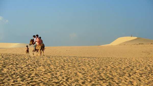 Kids ride horses at the white sand dunes