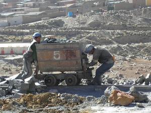 Men pushing one tonne of rocks outside the mine.