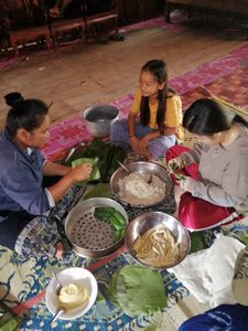 The ladies prepare sticky rice, banana and coconut parcels for steaming.