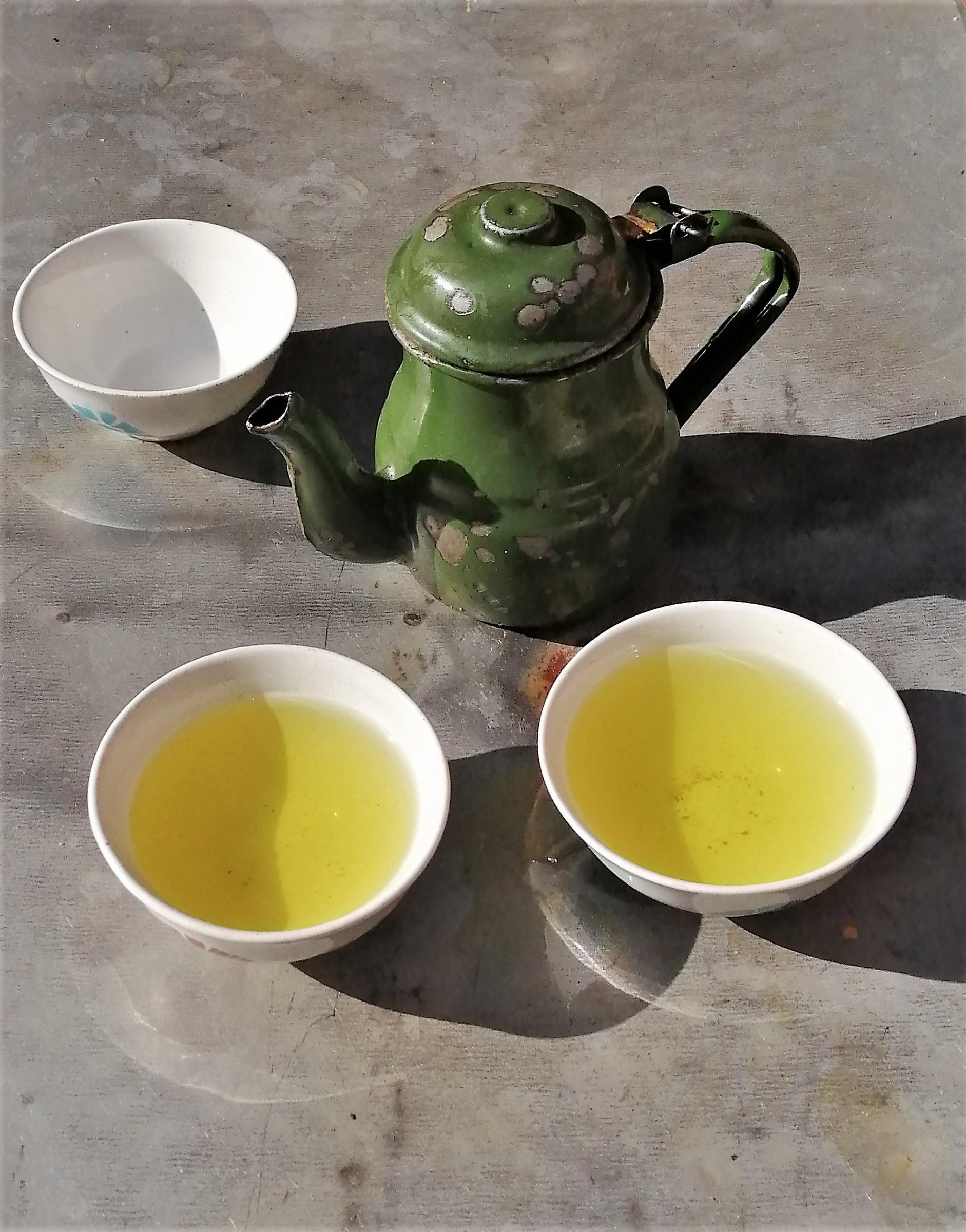 warm-cup-of-tea-with-teapot-flying-green-tea-leaves-in-the-air-and