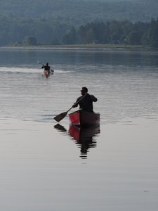 One in a canoe, another in a kayak