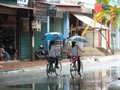 Girls cycling in the rain in Dien Bien Phu