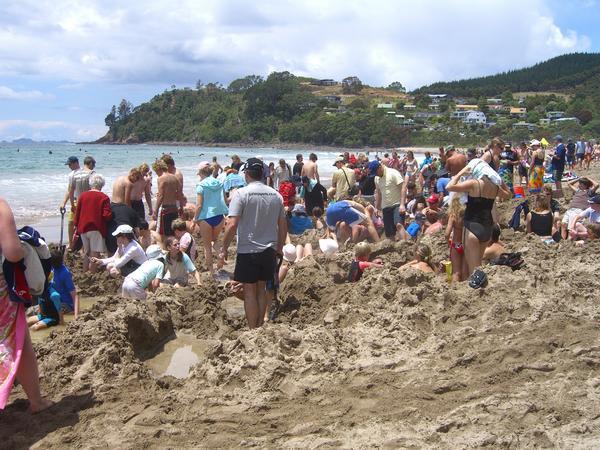 Crowds warming their feet at Hot Water Beach