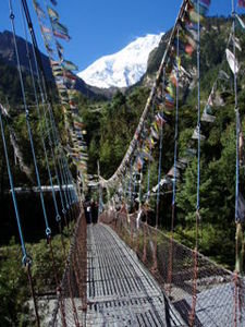 anja crossing a prayer flag protected bridge