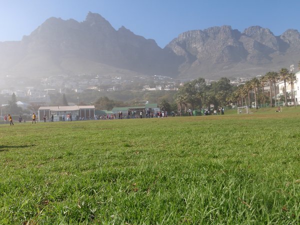 A soccer field with lots of little kids playing on it right by the water and the mtns as a back drop. Just amazing!