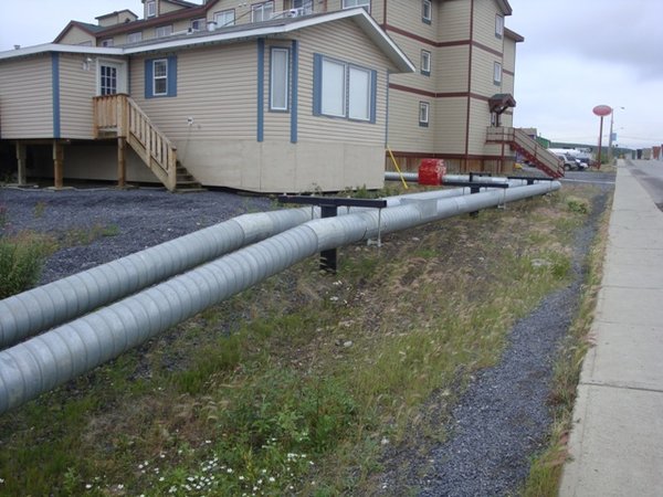 Heating pipes(?) between the houses in Inuvik.