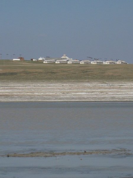Saline lake with yurts in distance