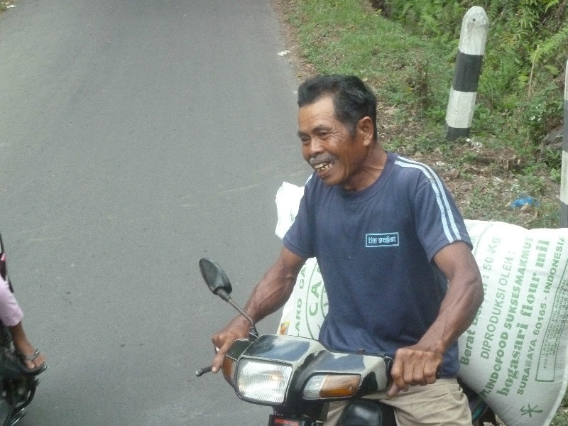 Happy chappy. 5 minutes earlier he had dropped his load of rice on te road !