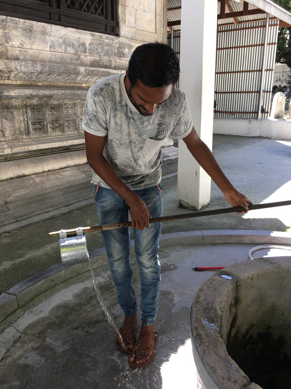 Kokko demonstrates washing feet with well water at the mosque