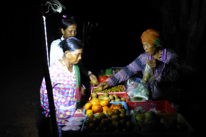 Woman with krama on head sells fruit