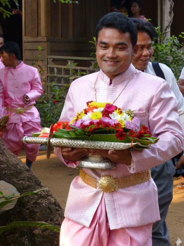 The groom bearing flowers