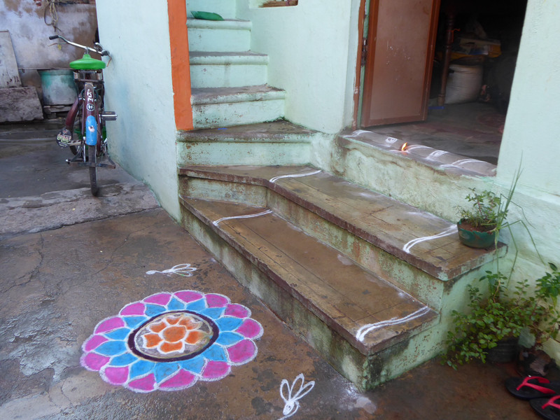 Rangoli and candle at top of step