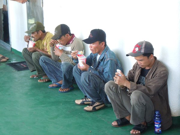 Four men feeding on a ferry