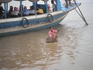 Little girl in massive bucket sailing along on the Tonle Sap