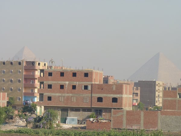 9. The finished, but unfinished buildings with pyramids in the background