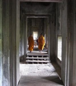 Monks stroll through the corridors of Angkor Wat