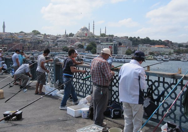 Fishermen hang their rods into the Bosphorus