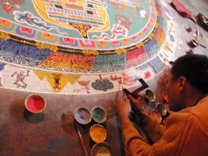 monk working on one of the mandalas