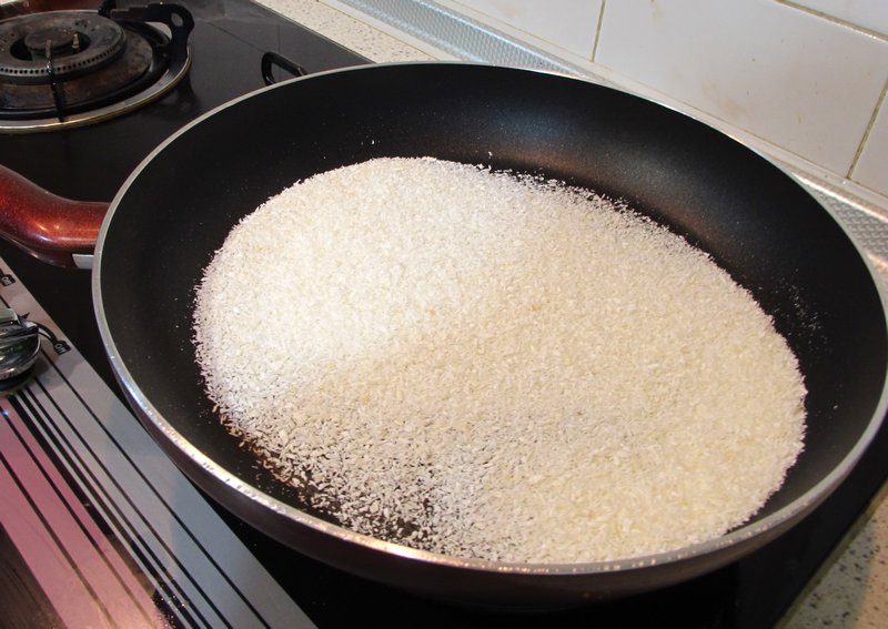 Placing Desiccated Coconut in a Pan on Low Heat