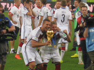 Schweinsteiger and Podolski pose with the trophy