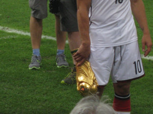 Podolski holding the trophy