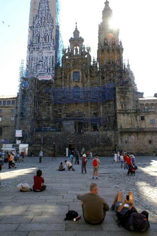 Santiago di Compostela - Cathedral under wraps and pilgrims taking a rest in the square
