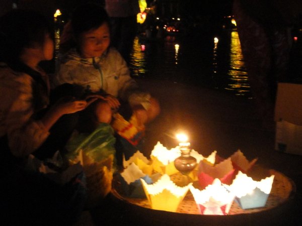 Local kids selling lanterns to place in the river 