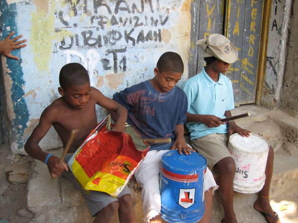 Kids playing music on self created instruments in the Favellah