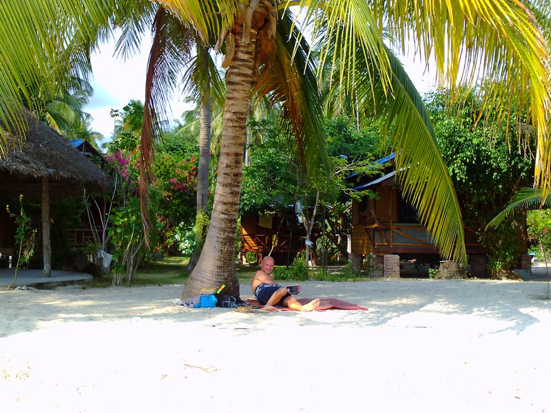 Chilling by a palm tree outside our hut