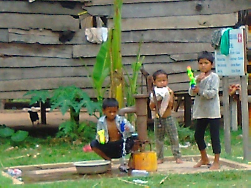 3 boys playing with the water pistols the girls bought