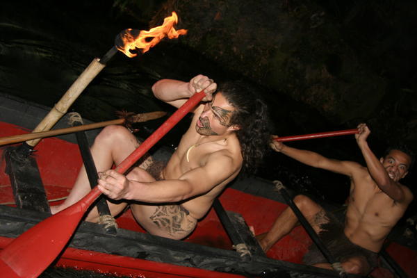 Maori warriors row up stream..