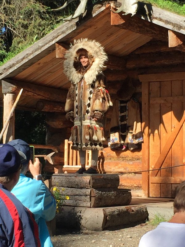 This young girl showing us a traditional coat made by her ancestors .