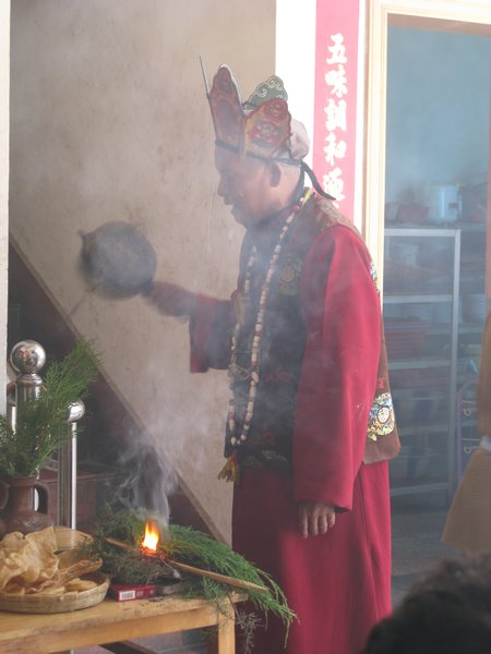 blind dongba conducting a ceremony against ghosts/ spirits/ evil