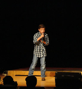 Boy on stage singing