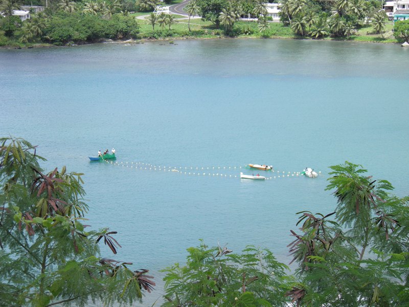 Fishermen casting nets in Umatac Bay