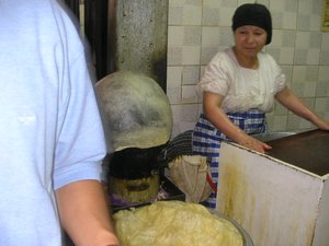 women makes some sort of fried dough