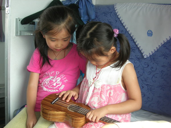 Kids from the next compartment examine Jacob's uke.
