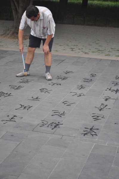 man doing caligraphy on the street