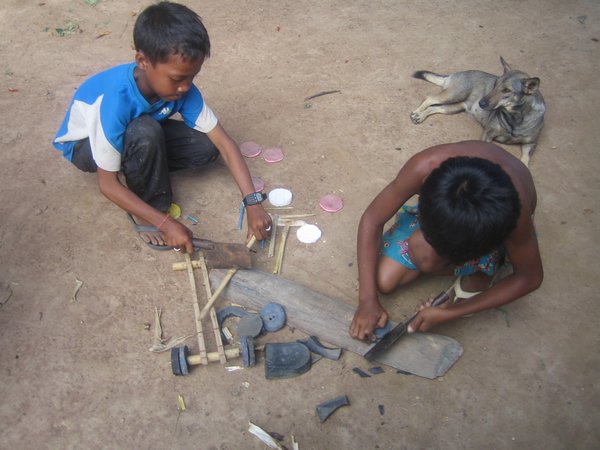 Kids making toy cars out of thongs and bamboo