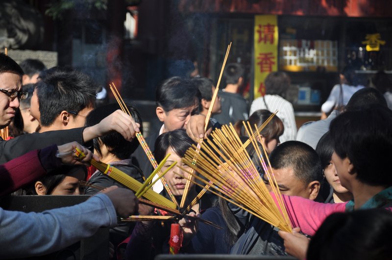 People lighting incense sticks at the Lamasery
