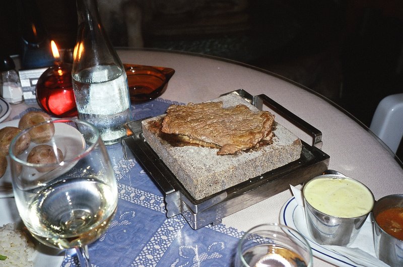 Steak getting cooked on a really hot rock