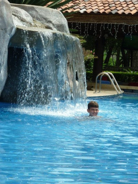 Me under a water fall at a pool
